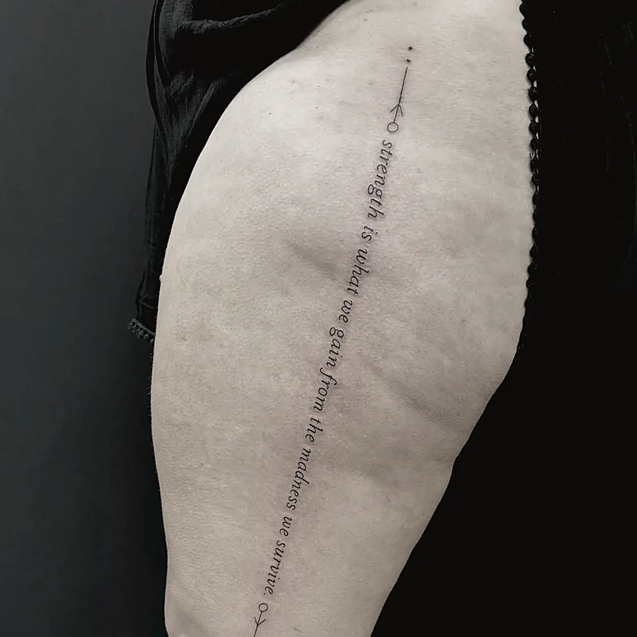 Script lettering tattoo running down the thigh